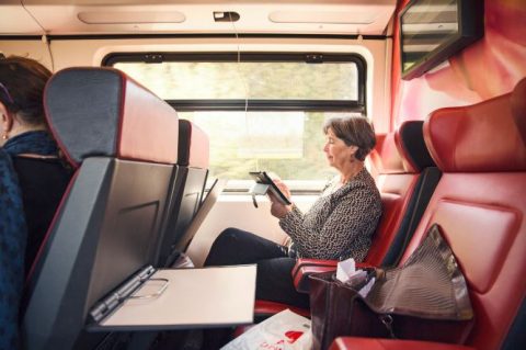 Reiziger in NS-trein maakt gebruik van WiFi