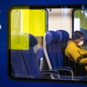 Een reiziger met een mondkapje in een NS-trein, foto: ANP
