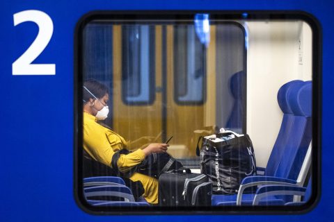 Een reiziger met een mondkapje in een NS-trein, foto: ANP