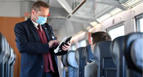 Een conducteur van Deutsche Bahn controleert kaartjes in coronatijd