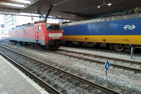 Een goederentrein van DB Cargo en een NS-trein op station Rotterdam centraal