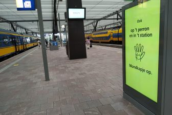 Een bord met een verwijzing naar de mondkapjesplicht op station Rotterdam Centraal