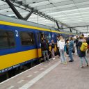 Reizigers met mondkapjes op het perron van Rotterdam Centraal