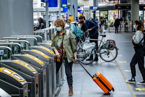 Reizigers met een mondkapje in de spits op station Den Haag Centraal, foto: ANP