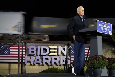 Joe Biden geeft een speech met op de achtergrond een goederentrein, foto: ANP